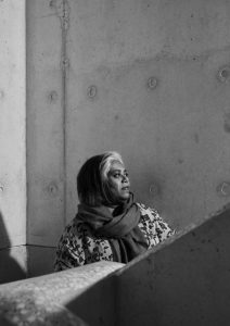 A black and white midshot of a woman looking away from the camera.